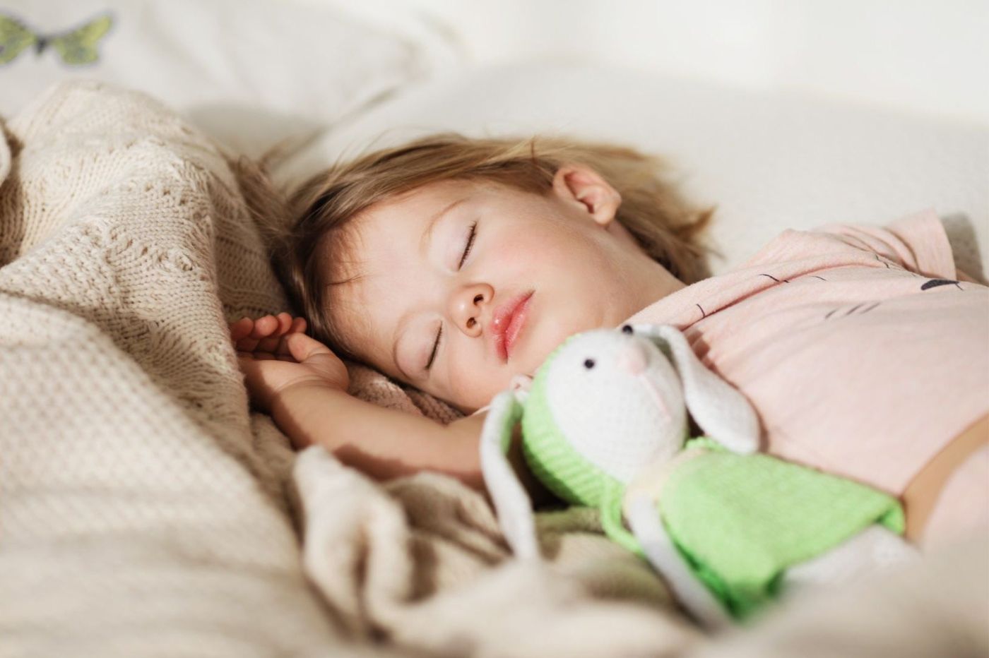 Hoogsensitief meisje slaapt rustig in haar eigen bed met haar knuffelkonijn