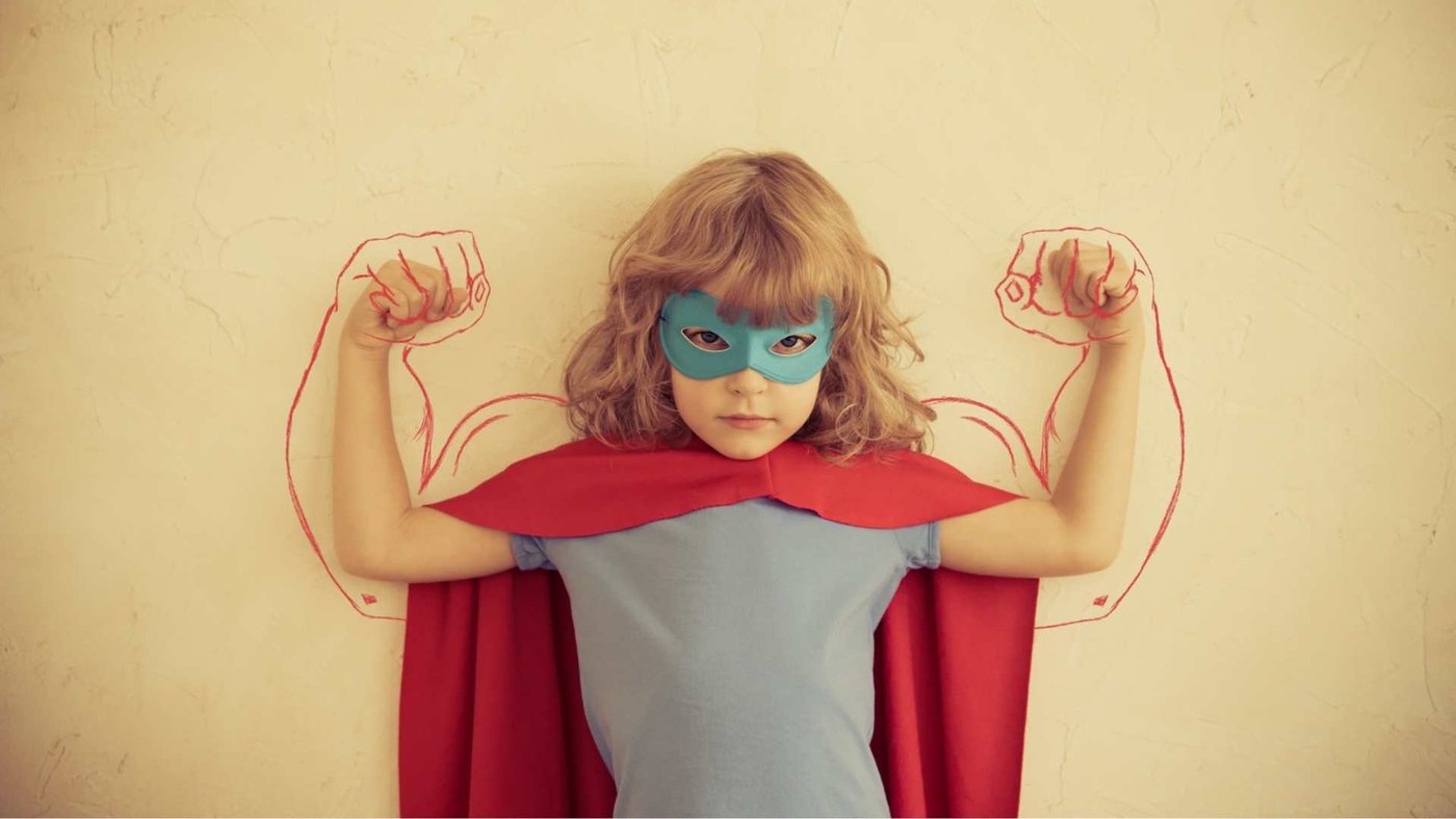 Hoogsensitief en strong-willed kind: meisje met masker, rode cape en getekende spierballen