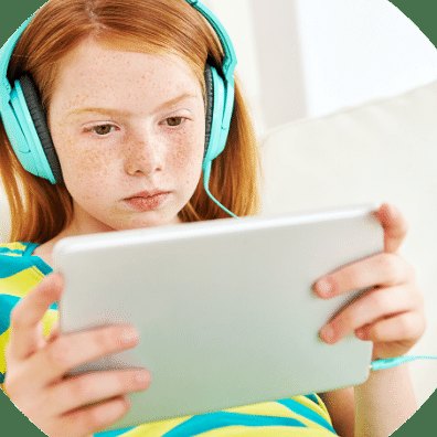 Meisje met koptelefoon kijkt geconcentreerd naar haar tablet